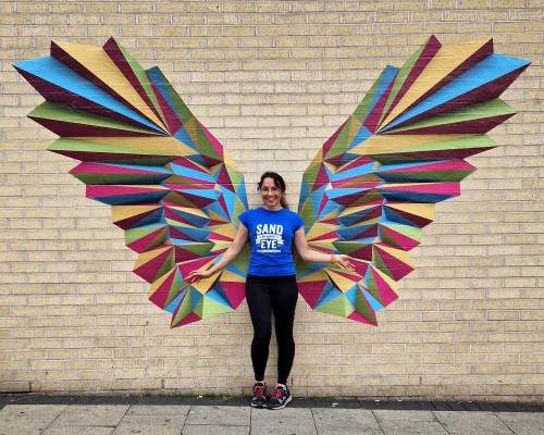 woman standing in front of wing shaped outdoor wall stickers